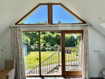 a large window with a view of a garden at Fernsplatt Farm Lodge in Truro