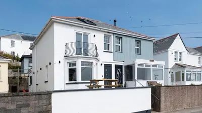 a white house with a fence in front of it at HipNautic, Mevagissey, Sleeps 6 in Mevagissey