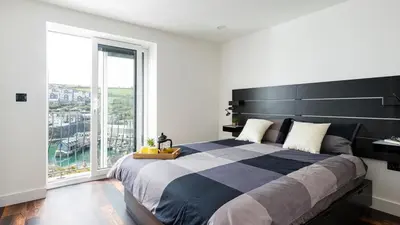 a bedroom with a large bed with a large window at HipNautic, Mevagissey, Sleeps 6 in Mevagissey