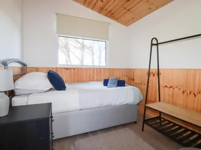 a bedroom with a bed with blue pillows and a window at 194 Atlantic Bays in Padstow