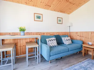 a living room with a blue couch and a table at 194 Atlantic Bays in Padstow