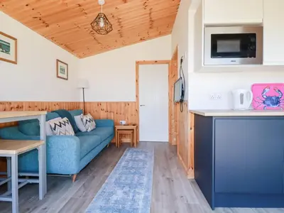 a living room with a blue couch and a table at 194 Atlantic Bays in Padstow