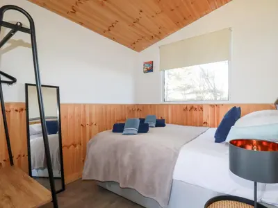 a bedroom with a bed with blue pillows on it at 194 Atlantic Bays in Padstow