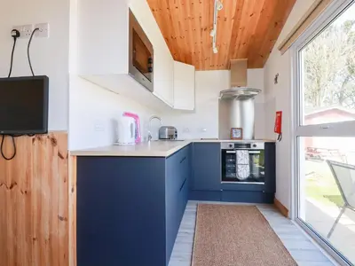 a kitchen with blue cabinets and a wooden ceiling at 194 Atlantic Bays in Padstow