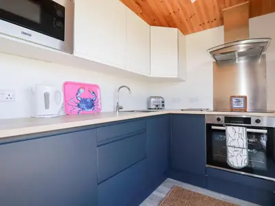 a kitchen with blue cabinets and a sink at 194 Atlantic Bays in Padstow