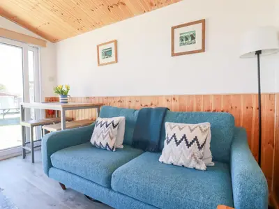 a blue couch in a living room with a table at 194 Atlantic Bays in Padstow