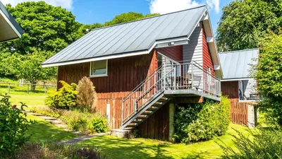 a barn house with a metal roof and a staircase at Ta Mill Cottages & Lodges - Meadowview Chalet 3 in Launceston