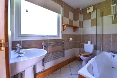 a bathroom with a sink and a toilet and a window at Ta Mill Cottages & Lodges - Meadowview Chalet 3 in Launceston