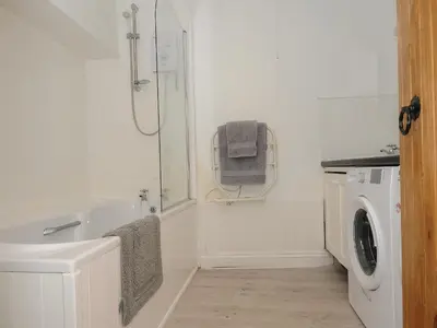 a bathroom with a sink and a washing machine at Mill House in Lostwithiel