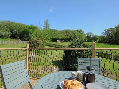 a table with a plate of croissants on a deck at Mill House in Lostwithiel