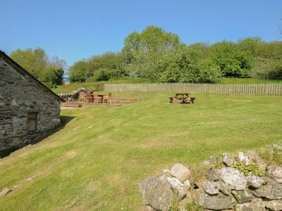 a park with a picnic table and a fence at Mill House in Lostwithiel