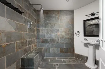 a bathroom with a sink and a stone wall at Mordros, St Ives in St Ives