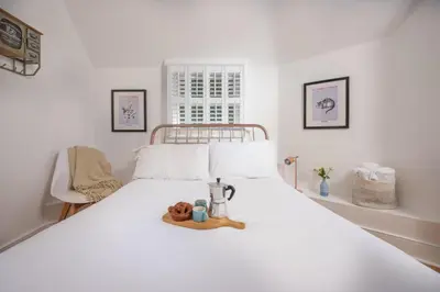 a white bed with a tray of food on it at Mordros, St Ives in St Ives