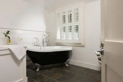 a bathroom with a black and white tub and a window at Mordros, St Ives in St Ives