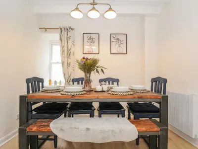 a dining room with a table with chairs and flowers at Carvannel Cottages in Camborne