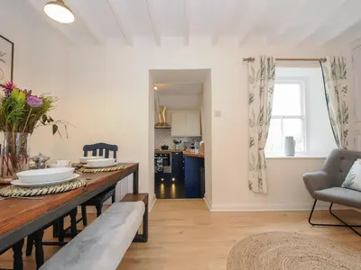 a kitchen with a table and a dining room at Carvannel Cottages in Camborne
