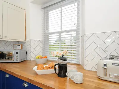 a kitchen counter with a coffee maker and a bowl of bread at Carvannel Cottages in Camborne