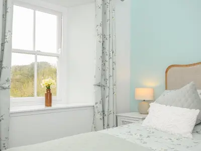 a bedroom with a bed and a window at Carvannel Cottages in Camborne