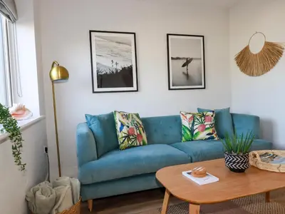 a blue couch in a living room with a table at The Waves in Newquay