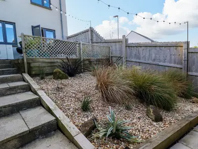 a garden with a fence and some plants at The Waves in Newquay