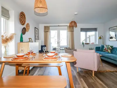 a living room with a table and a blue couch at The Waves in Newquay