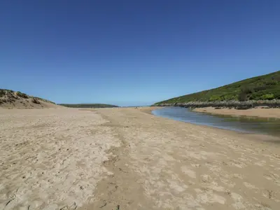 a view of a sandy beach next to the water at The Waves in Newquay