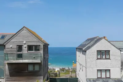 a house with a wooden door next to a building at Reflections in St Ives