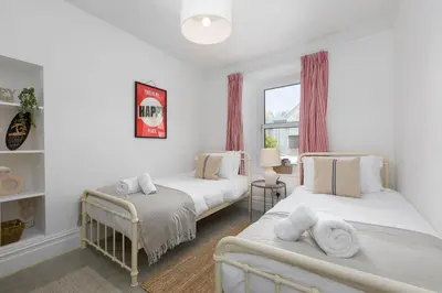 a bedroom with two beds and a window at Reflections in St Ives