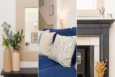 a living room with a blue couch and a fireplace at Reflections in St Ives