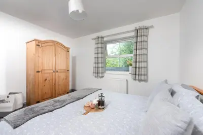a bedroom with a bed with a stuffed animal on it at Hoopers Lodge, Hot Tub, Pet Friendly in Ludgvan