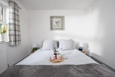 a bedroom with a bed with two candles on it at Hoopers Lodge, Hot Tub, Pet Friendly in Ludgvan