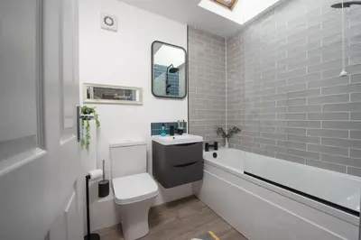 a bathroom with a toilet and a sink and a mirror at Hoopers Lodge, Hot Tub, Pet Friendly in Ludgvan