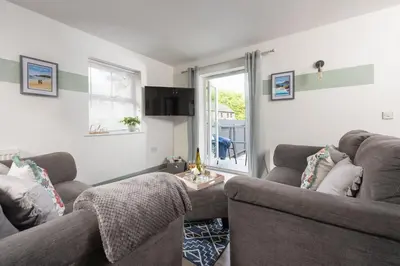 a living room with two couches and a window at Hoopers Lodge, Hot Tub, Pet Friendly in Ludgvan
