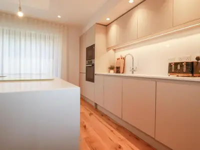 a kitchen with white cabinets and a white counter top at 7 Longshore in Newquay