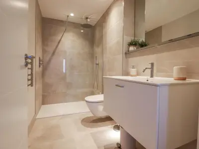 a bathroom with a sink and a toilet and a shower at 7 Longshore in Newquay