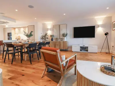a dining room with a table and a flat screen tv at 7 Longshore in Newquay