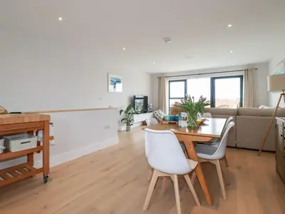a living room with a table and a couch at 11 Ebbtide in Newquay
