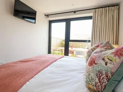 a bedroom with a bed and a large window at 11 Ebbtide in Newquay