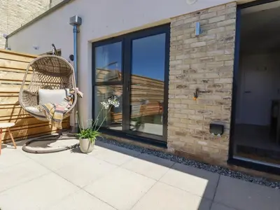 a wicker chair sitting on a patio with a window at 11 Ebbtide in Newquay