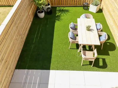 a patio with a table and chairs on grass at 11 Ebbtide in Newquay