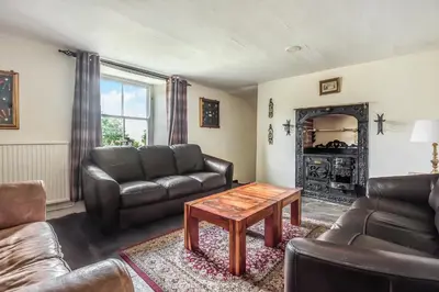 a living room with a couch and a table at Trehellas House Hotel & Courthouse restaurant in Bodmin