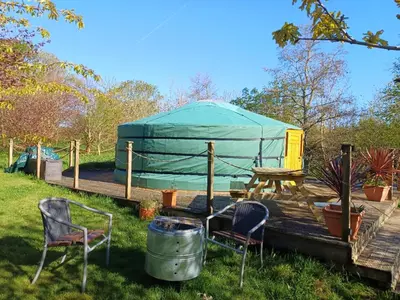 a gazebo with two chairs and a table and a table and chairs at The Yurt in Cornish woods a Glamping experience in Penzance