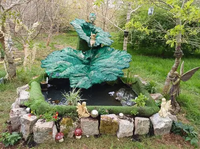 a garden statue of a large leaf with a pond at The Yurt in Cornish woods a Glamping experience in Penzance