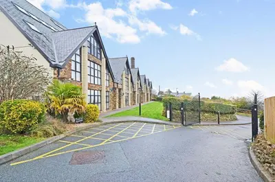 a house with a gate in the middle of a street at 5 mins from the Eden Project Baybreeze Holiday Apartment, Sea Views, Super Kingsize Beds in St Austell