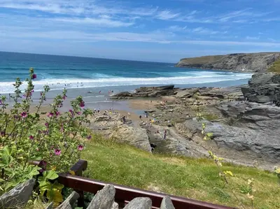 a beach with people on the sand and the ocean at 5 mins from the Eden Project Baybreeze Holiday Apartment, Sea Views, Super Kingsize Beds in St Austell