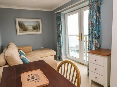 a living room with a couch and a table at Looe Island View in Torpoint