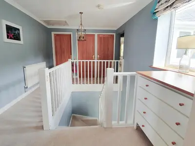 a white staircase in a room with a stair case at Looe Island View in Torpoint