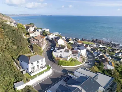 an aerial view of a residential neighborhood next to the ocean at Looe Island View in Torpoint