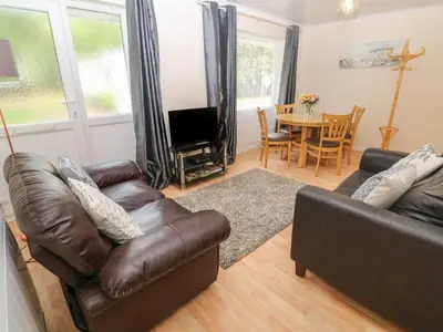 a living room with a leather couch and a television at 11 Tremore in Liskeard