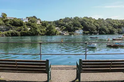 a bench sitting next to a lake with boats in it at 11 Tremore in Liskeard